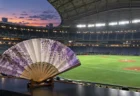 試合前のナイター球場のグラウンドと、手前に置かれた和柄の扇子