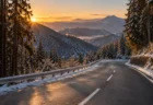 冬の朝日に照らされた雪の残る山あいの坂道