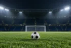 ナイター照明に照らされた無人のスタジアムとピッチに置かれたサッカーボール