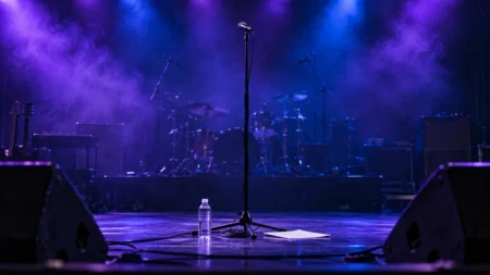 紫と青の照明がにじむライブ会場のステージ中央に立つボーカルマイクとスタンド