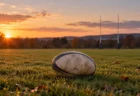 秋の夕方、人のいない天然芝のラグビーグラウンドの中央に置かれた1個のラグビーボール
