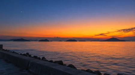 夕暮れの瀬戸内海に浮かぶ島々のシルエットと、空に光る一番星