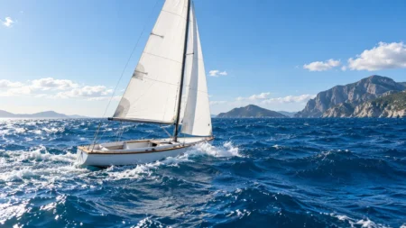 青い海に浮かぶ無人のヨットと白い帆