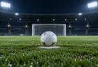 夜のサッカー場のペナルティーエリアに置かれたボールと白線
