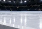 照明に照らされたスケートリンクの氷面とフェンス