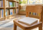 午後の光が差す図書館の児童書コーナーと木の書棚