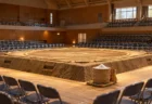 体育館の中央に設けられた土俵と塩かご、周りに並ぶ客席の椅子