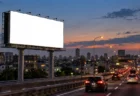高速道路沿いに立つ大きな屋外看板と夕方の空