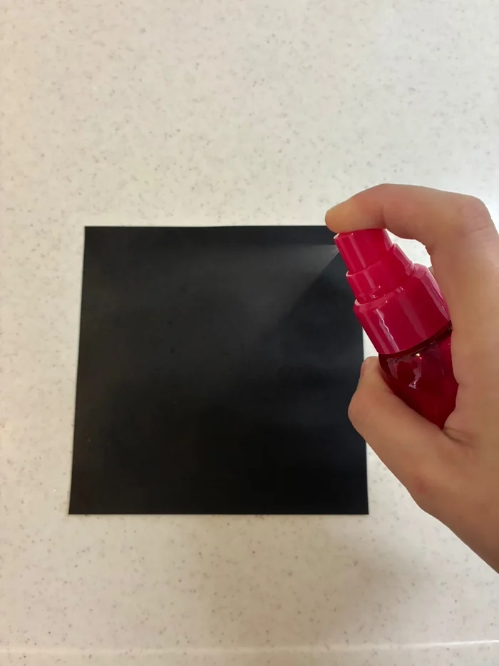 画像 黒い折り紙にメイク キープ ミストを吹きかけている様子