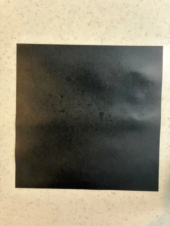 画像 メイク キープ ミストを吹きかけた後の黒い折り紙に付いた細かい粒
