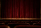 照明を落とした無人の劇場で、木の舞台に下りた深紅の幕