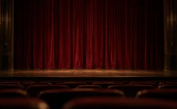 照明を落とした無人の劇場で、木の舞台に下りた深紅の幕