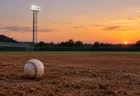 夕暮れの野球場の内野に置かれた硬式野球ボール