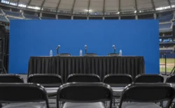 ドーム球場の記者会見場に並ぶマイクと空席