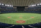 照明がともった無人のドーム球場の内野と観客席