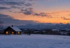 冬の夕暮れの北海道の雪原と丸太小屋
