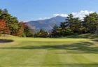秋晴れのゴルフ場、旗が立つグリーンと手前の花道