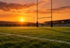 夕暮れのラグビー場、ゴールポストと芝のグラウンドに長く伸びる影