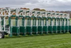 曇り空の下、芝コースに置かれた競馬のスターティングゲート