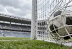 スタジアムのゴールネットを揺らすサッカーボール