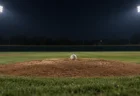 夜の照明に照らされた無人の野球場のマウンドに置かれた白い硬式ボール