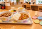 お子様セットのトレーとカラフルな反射キーホルダーが並ぶ飲食店のカウンター