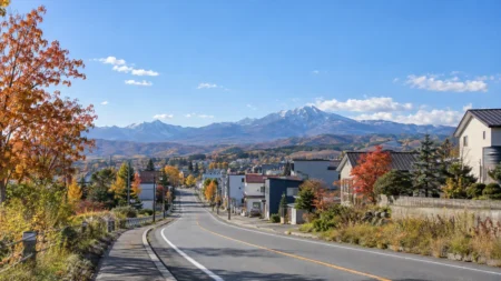秋晴れの北海道の街のロードサイドと遠くの山並み