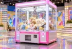 カラフルなテレビスタジオのセットに置かれた大きなクレーンゲーム機