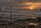 夕暮れの荒野に霧が漂い、無人のスタンドマイクが1本立つ風景