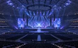 開演前のドーム会場で、青と紫のライトが無人のステージを照らす様子
