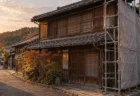 秋の夕方、古い町並みに建つ木造2階建ての民家