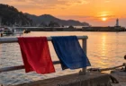 夕方の三陸の漁港、岸壁で風になびく赤と青の2本の手ぬぐい