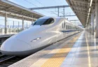 朝の光が差し込む駅のホームに停車する白い新幹線車両
