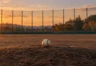 夕暮れの誰もいない野球グラウンド、マウンドに置かれた硬式ボール