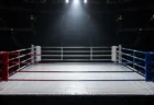 照明に照らされた無人のキックボクシングのリング