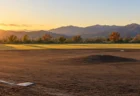 秋の夕方、西日が差す無人の地方球場の内野
