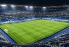 夜の照明に照らされた欧州の大型サッカースタジアムのピッチ