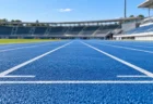 陸上競技場の青いトラックに描かれたレーンの白線