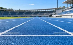 陸上競技場の青いトラックに描かれたレーンの白線