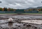 雨上がりの地方球場のマウンドとホームベース付近に置かれた白い硬式球