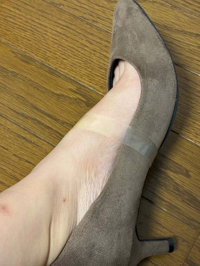 透明パンプスバンドを装着したグレージュのパンプスを斜め横から撮影。甲から靴の側面へバンドが回っている