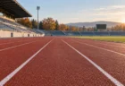 朝の陸上競技場の全天候型トラックと100mの直線レーン