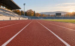 朝の陸上競技場の全天候型トラックと100mの直線レーン