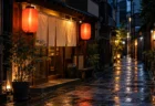 夜の路地裏に赤い提灯と白い暖簾がともる小さな和風の食堂と、雨に濡れた石畳