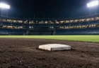 夜の野球場、照明に照らされた内野の黒土と緑の人工芝