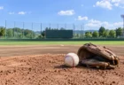 晴れた日の無人の野球場のマウンドに置かれた白い硬式ボールとグラブ