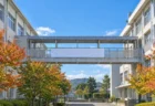 秋晴れの空の下に建つ学校の校舎と渡り廊下