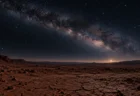 荒れ果てた赤茶色の大地の地平線と、夜明け前の空に広がる天の川