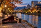 秋の夕方、都市を流れる川沿いの遊歩道に開いて置かれたアコースティックギターのケース