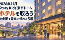 2026年11月 Stray Kids東京ドームのホテルを取ろう。徒歩圏と電車で帰れる5選。ホテル前を歩く旅行者のイラスト。